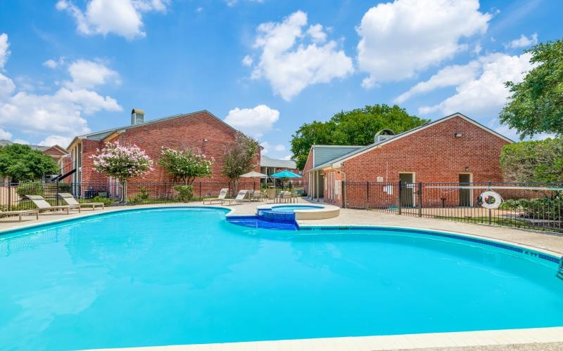 a swimming pool in front of a brick building